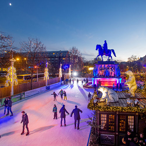 Eisbahn mit Blick auf das beleuchtete Reiter-Denkmal Heumarkt